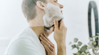 美容師がひげを剃る男性